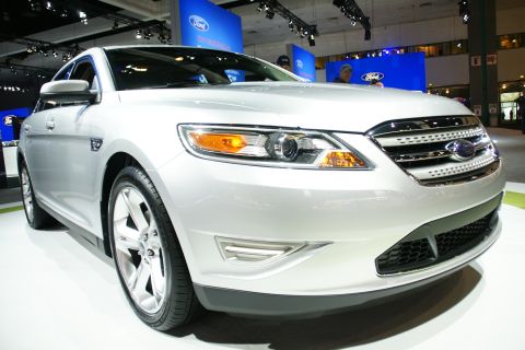 1993 Ford Taurus - A silver Ford Taurus is displayed at an auto show with Ford branding in the background.
