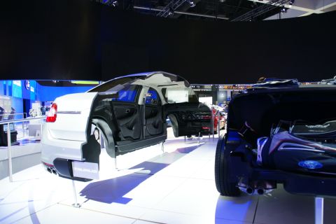 1993 Ford Taurus - A cutaway car display reveals the inner workings of a white sedan, with another vehicle visible in the foreground.