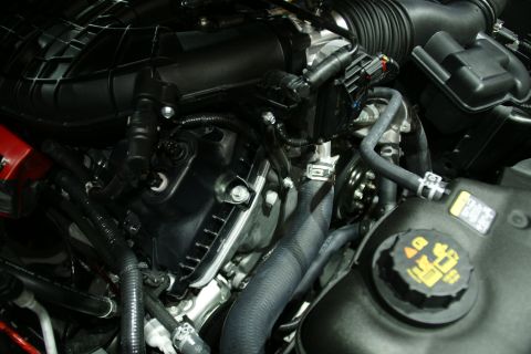 1993 Ford Taurus - Close-up view of an engine bay, various hoses and a coolant reservoir cap with warning symbols.