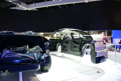 1993 Ford Taurus - A cutaway car display reveals its internal structure and engine components at an auto show.