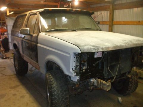 1995 Ford Bronco - This Ford Bronco appears to be undergoing bodywork in a garage, with its front end partially dismantled.