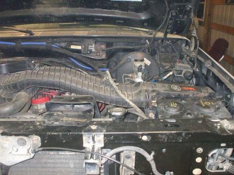 1995 Ford Bronco - The engine bay of a vehicle, showing the air intake system and brake booster assembly.