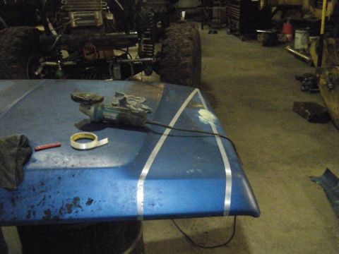 1978 Ford Bronco - A blue hood with racing stripes is prepped for work with an angle grinder and tape.
