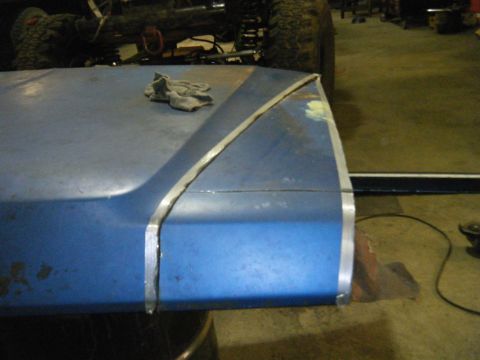1978 Ford Bronco - Blue hood section with metal trim detail and a rag on top.