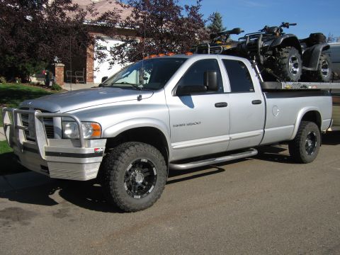 2005 Dodge 3500 - Silver 2005 Dodge 3500 pickup truck equipped with a brush guard and carrying two ATVs in its bed.