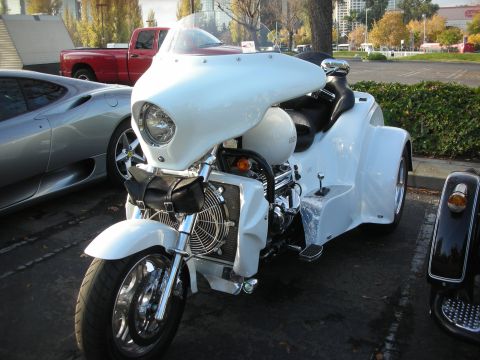 1998 Ford Crown Victoria - A white trike is parked in a lot with other vehicles visible.