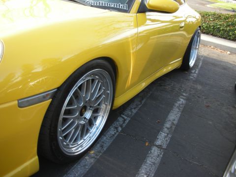 1998 Ford Crown Victoria - A bright yellow sports car is shown from the side, custom wheels and a lowered stance.