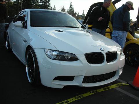 1998 Ford Crown Victoria - White BMW M3 coupe parked next to a yellow Lamborghini at an outdoor car event.