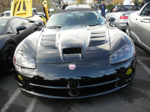 1998 Ford Crown Victoria - Front view of a black Dodge Viper with yellow fog lights and a prominent hood scoop.