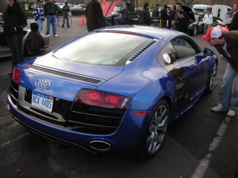 1998 Ford Crown Victoria - A blue Audi R8 is parked at an outdoor event, with a person leaning in to look at it.