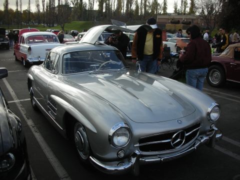1998 Ford Crown Victoria - A classic Mercedes-Benz 300 SL Gullwing is displayed at a car show, with other vehicles visible.