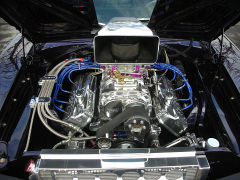 1998 Ford Crown Victoria - The engine bay of a custom car features a prominent supercharger and polished components.