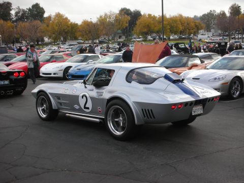1998 Ford Crown Victoria - A classic silver 1967 Chevrolet Corvette Stingray is displayed among other vehicles at an outdoor event.