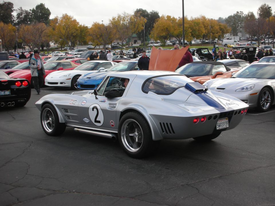 Silver 1967 Chevrolet Corvette Stingray with blue racing stripes and number 2 on the door, parked outdoors