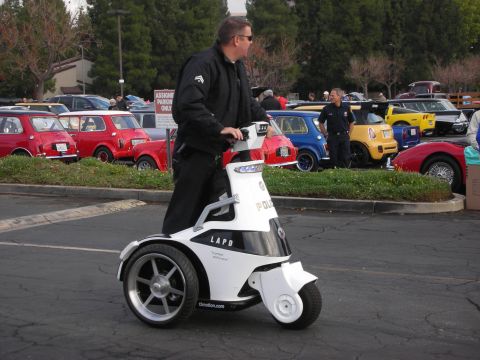 1998 Ford Crown Victoria - Man rides a white LAPD police segway with other cars parked behind him.