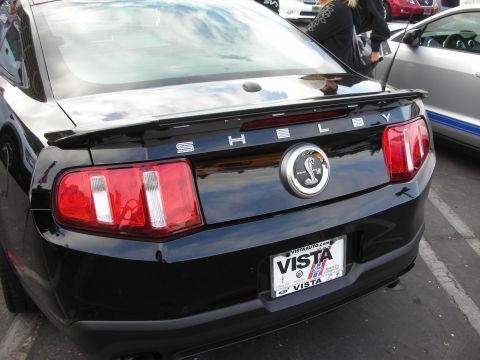 1998 Ford Crown Victoria - Rear view of a black Shelby Mustang, the iconic cobra emblem and a VISTA license plate frame.