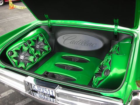 1998 Ford Crown Victoria - The trunk of a car is modified with a custom green audio system and speakers, displaying a Cadillac emblem.