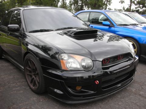 1998 Ford Crown Victoria - A black Subaru Impreza WRX is parked next to a blue Subaru WRX.
