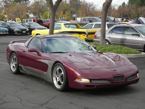 1998 Ford Crown Victoria - Maroon Corvette C5 parked at an outdoor event with other vehicles visible in the background.