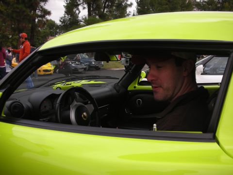 1998 Ford Crown Victoria - Man sits inside a bright green sports car, with other vehicles visible in the background.