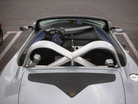 1998 Ford Crown Victoria - The interior of a silver sports car is visible from a high angle, showing the dashboard and roll cage.