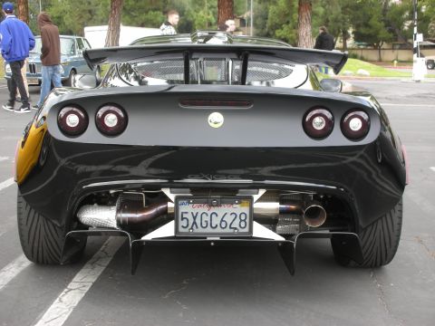1998 Ford Crown Victoria - Rear view of a black Lotus Exige S2, a large spoiler and dual exhaust pipes.