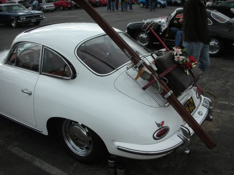 1998 Ford Crown Victoria - A classic white Porsche is outfitted with a rear rack carrying skis and a suitcase, ready for a trip.