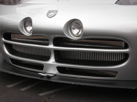 1998 Ford Crown Victoria - Close-up of a silver Dodge Viper's front fascia, showing its distinctive grille and headlights.