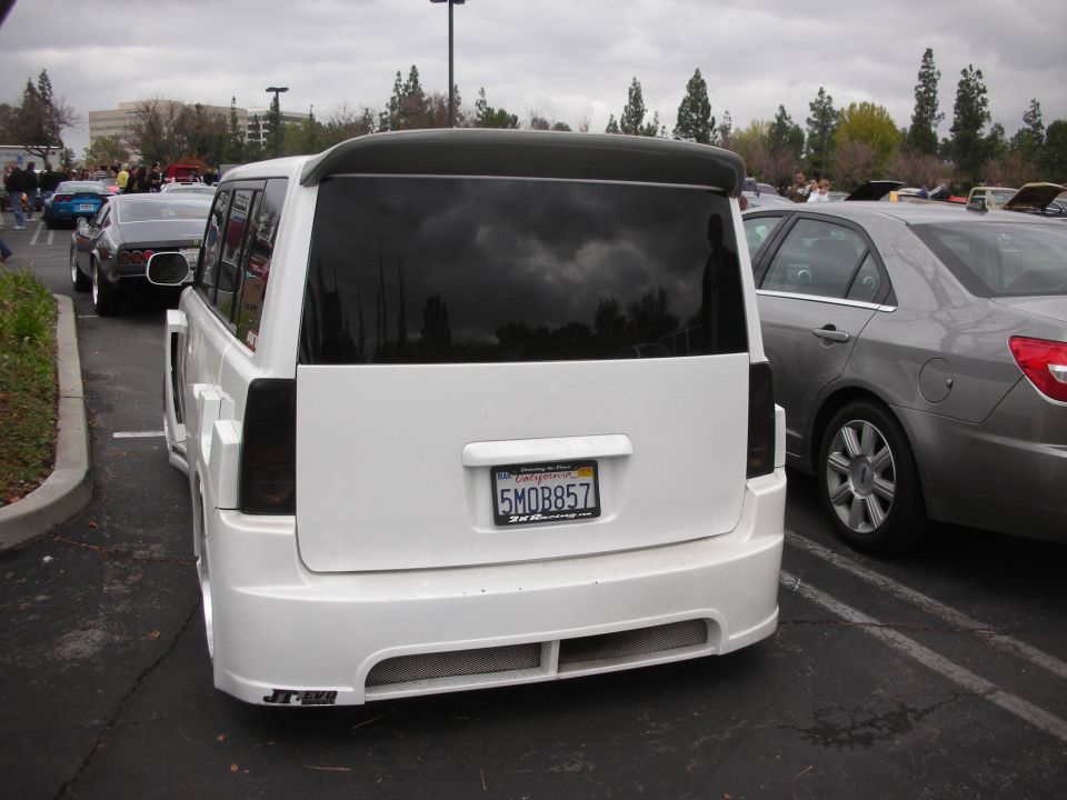 Rear view of a white SUV with a spoiler and custom body kit. License plate is 5MOB857