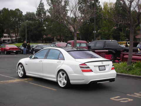 1998 Ford Crown Victoria - A white Mercedes-Benz sedan is parked in a lot with other vehicles visible in the background.