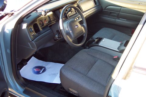 2001 Ford Crown Victoria - The interior of a 2001 Ford Crown Victoria, a police-style center console and a Saab branded floor mat.