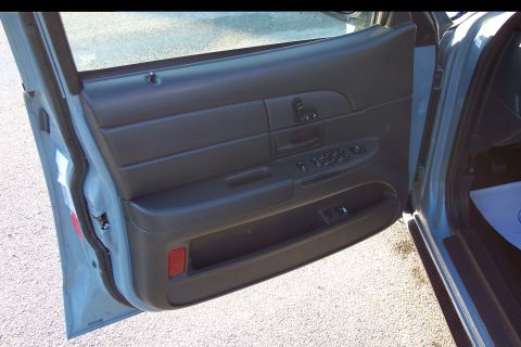 2001 Ford Crown Victoria - Front passenger door panel interior with window controls and a red reflector.