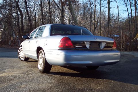 2001 Ford Crown Victoria - Rear view of a white sedan parked outdoors.