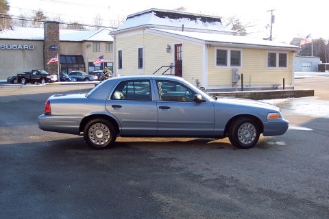 2001 Ford Crown Victoria - A silver 2001 Ford Crown Victoria sedan is parked outdoors, viewed from the side.