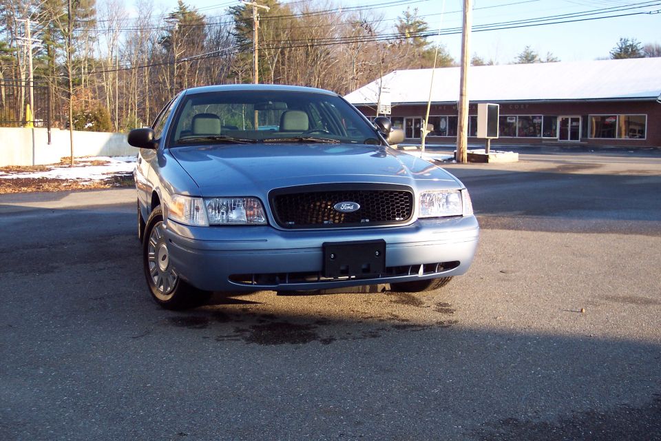 Front view of a blue 2001 Ford Crown Victoria parked outside