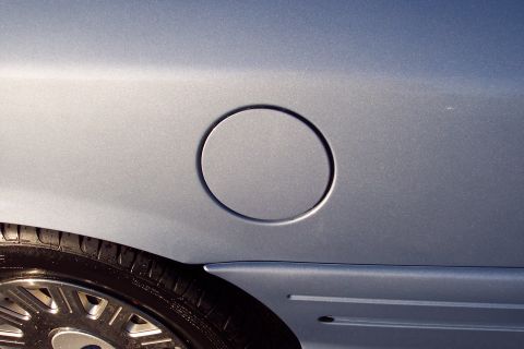 2001 Ford Crown Victoria - Side view of a car's fuel door and wheel.