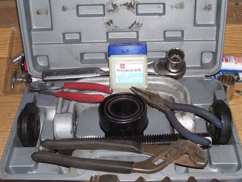 1991 Ford Bronco - Toolbox containing various hand tools and a small jar of petroleum jelly.