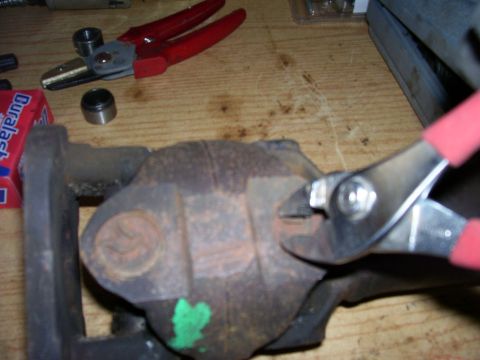 1991 Ford Bronco - Close-up of a vehicle drive shaft component being worked on with pliers, likely for a U-joint repair.