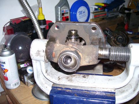 1991 Ford Bronco - Universal joint assembly being worked on in a vise, with tools and fluids nearby.