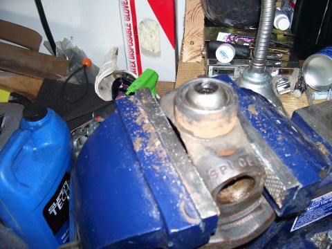 1991 Ford Bronco - A vehicle part, likely a universal joint, is secured in a vise for repair or inspection.