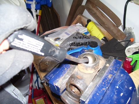 1991 Ford Bronco - A ball joint is secured in a vise, with a tool applying pressure to it.