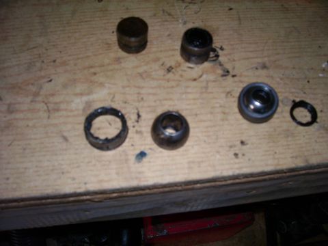 1991 Ford Bronco - Various disassembled automotive components are scattered across a workbench, awaiting reassembly or replacement.