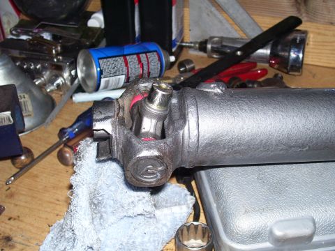 1991 Ford Bronco - A close-up view of a vehicle's driveshaft universal joint, surrounded by various tools and a spray can.