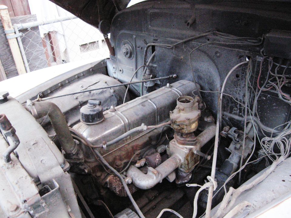 engine bay with inline six engine, carburetor, and wiring