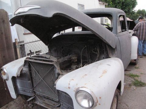 1986 Ford Bronco - A 1954 Chevrolet truck is shown from the front with its hood open, revealing the engine compartment.