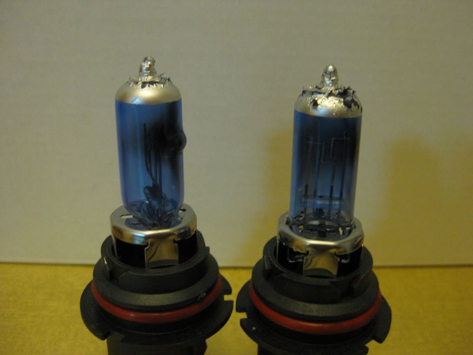 Two blue glass headlight bulbs with silver bases and visible filaments