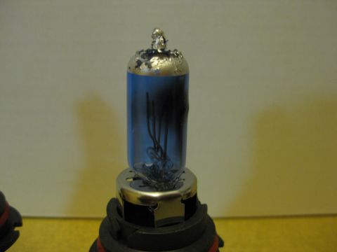 1994 Ford Thunderbird - Automotive headlight bulb with blue glass and internal filament wires.