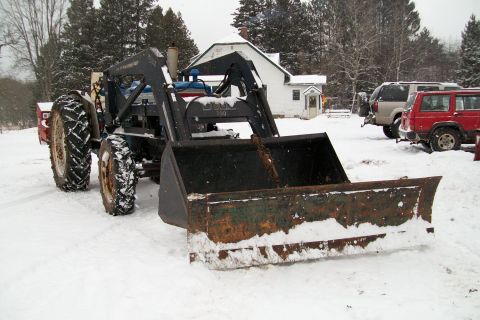 2000 Chevrolet Tahoe - Tractor with front loader in a snowy yard, with two SUVs parked nearby.