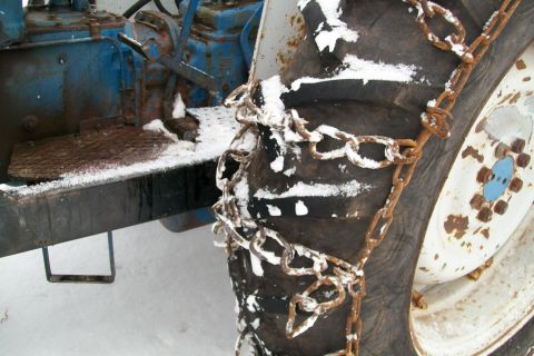 2000 Chevrolet Tahoe - Close-up of a tractor tire fitted with snow chains, ready for winter conditions.