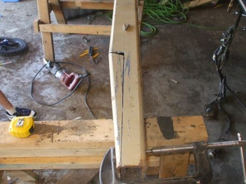 1995 Ford Bronco - Close-up of a metal beam undergoing work, with tools and a tape measure visible.